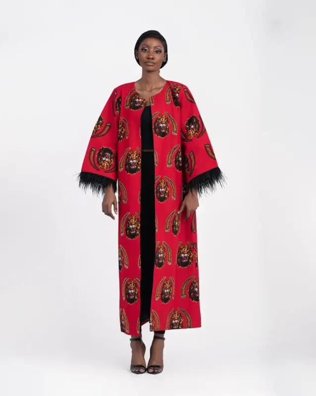 Model in a long red printed coat with feather-trimmed sleeves